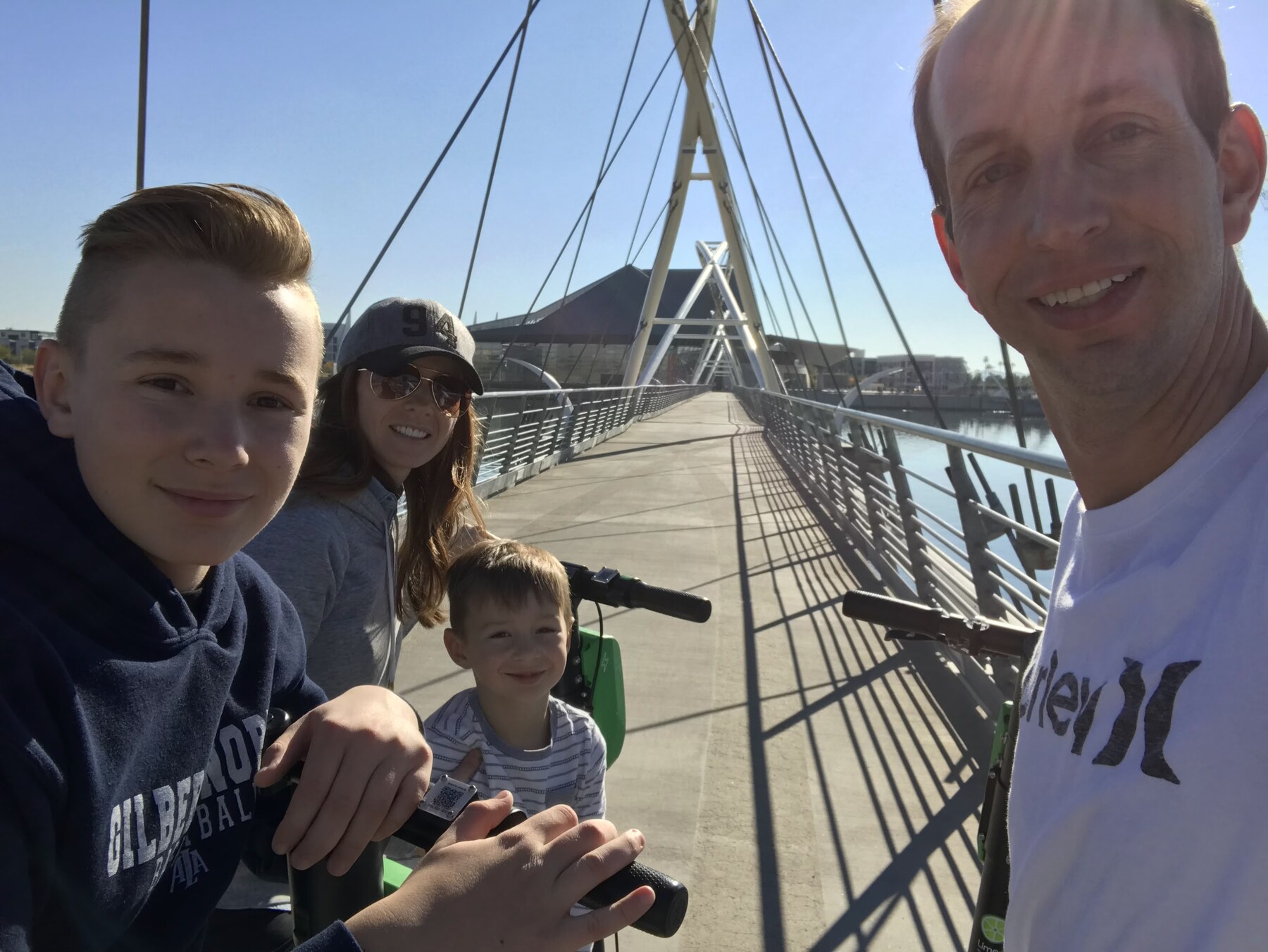 Doug and family on the Tempe Town Lake Pedestrian Bridge with electric scooters