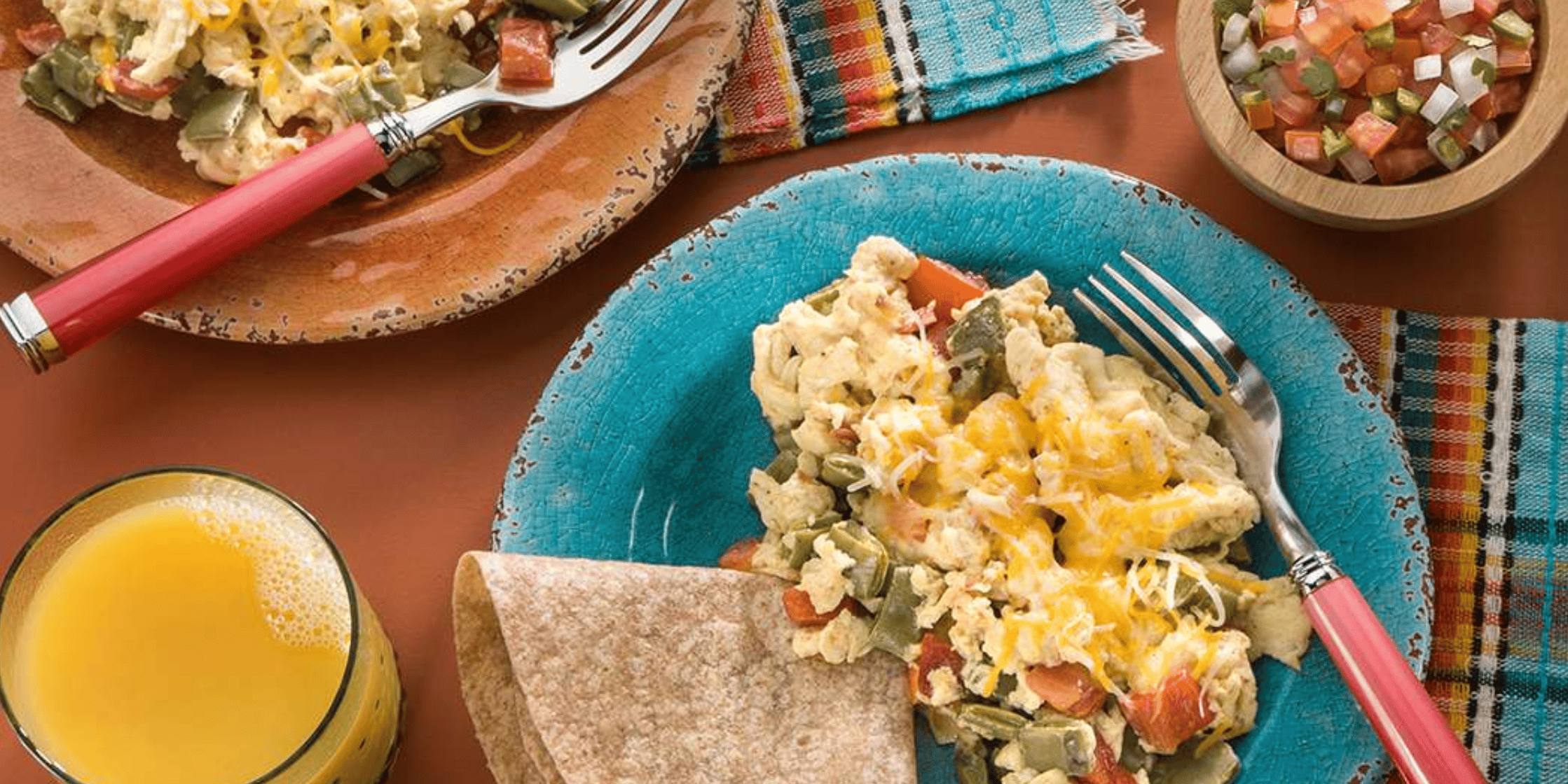 A colorful breakfast of scrambled eggs with nopales, tortilla, pico de gallo, and orange juice — a culturally-rooted Food is Medicine meal.
